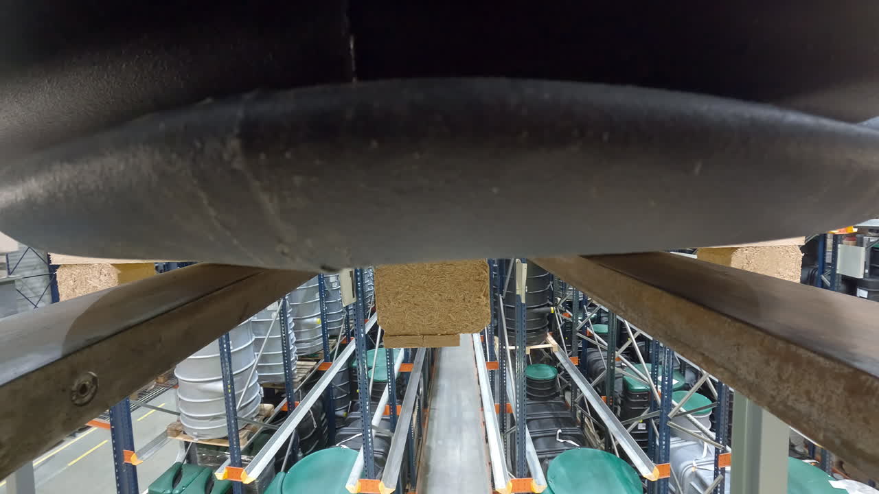 큰 플라스틱 짐을 운반하기 위해 뒤로 운전하는 지게차의 클로즈업 샷