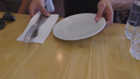 arranging cutlery and plate on table