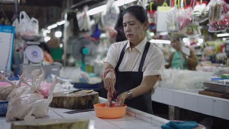 woman butchering chickens at a market