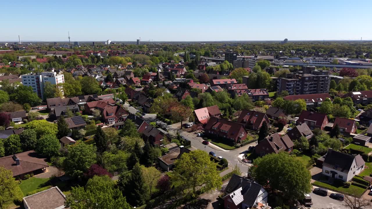 Luchtfoto met drone van een Duitse stadswijk in de lente met bomen, huizen en appartementencomplexen. Zonnig residentieel stadsbeeld dat gemengde bebouwing, rustige straten en een stedelijke gemeenschap in Duitsland toont.