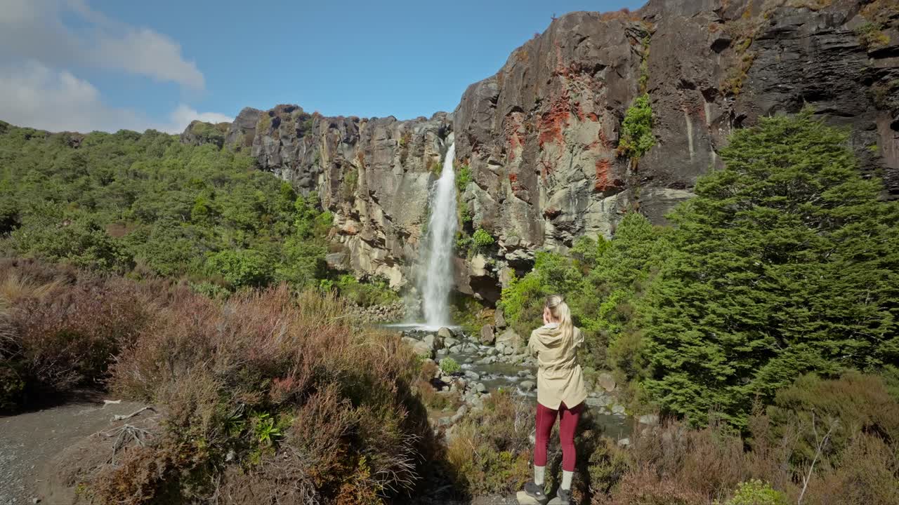una fotógrafa solitaria tomando fotos de la hermosa cascada de taranaki