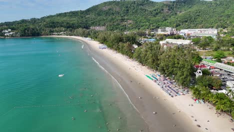 las imágenes de drones capturan la bulliciosa playa de phuket, la exuberante vegetación y el vibrante paisaje urbano bajo la brillante luz del día.