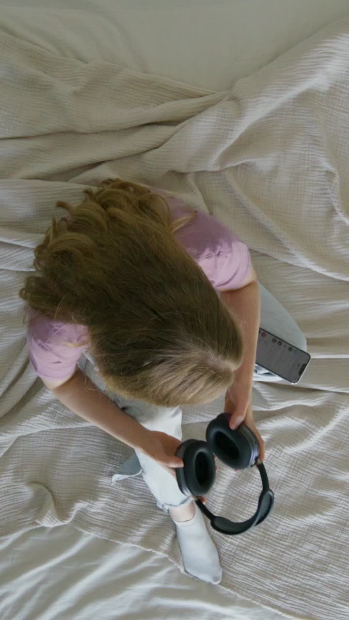 mujer escuchando música en su teléfono en la cama