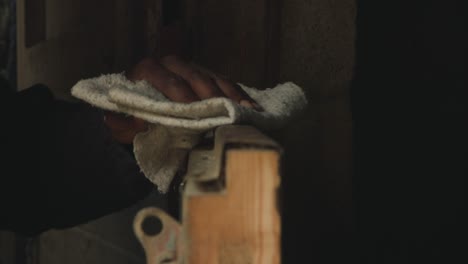 shepherd's hand wiping stable door with cloth at the barn - close up, static shot