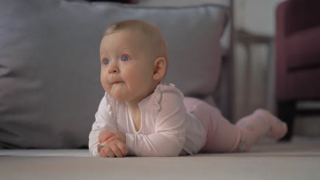 Indoor-portrait-of-baby-girl-lying-on-the-belly