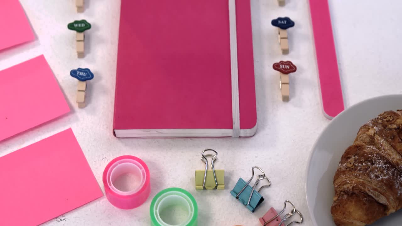 accesorios rosados, croissants y artículos de papelería sobre fondo blanco 4k