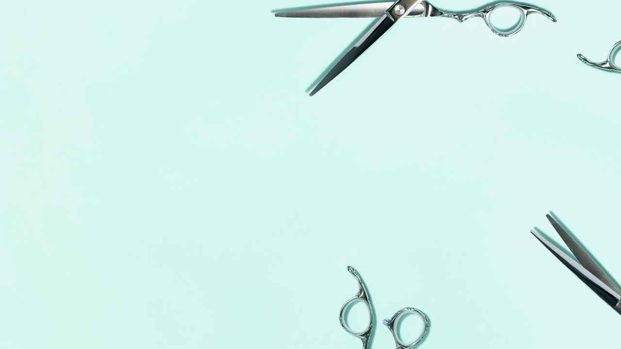 Flat lay of professional silver hair cutting shears set on green background. Hairdresser salon equipment and haircut work tools concept during quarantine