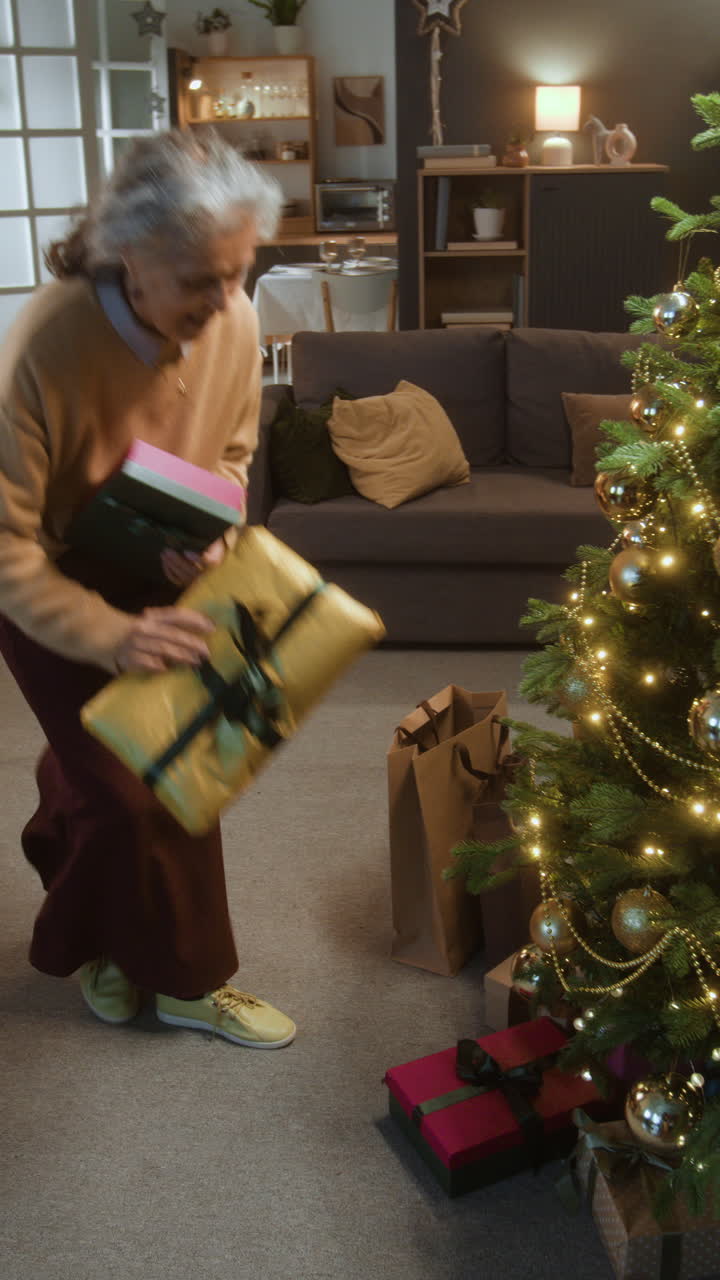 Senior Woman Placing Gifts Under Christmas Tree