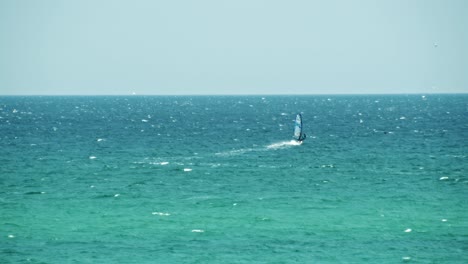 windsurfista en un mar turquesa