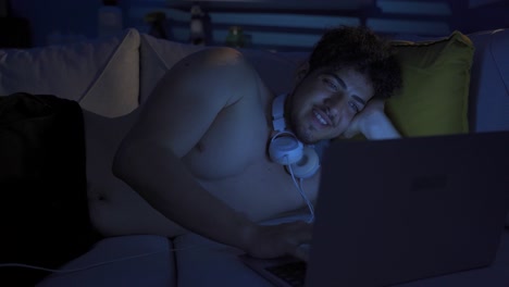 delighted and cheerful young man looking at laptop.