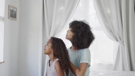 Happy-african-american-mother-and-daughter-brushing-hair-in-bedroom,-slow-motion