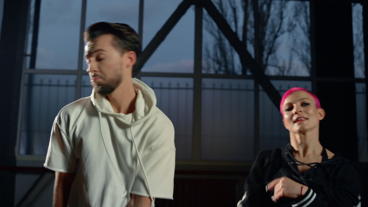 gente deportiva bailando en la clase oscura. una hermosa pareja entrenando movimientos de baile.