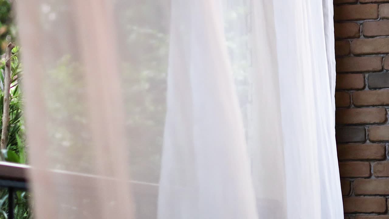 la cortina se balancea suavemente con la vista al aire libre