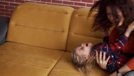 Mother-and-small-child-preschool-girl-enjoying-bonding,-jumping-on-couch