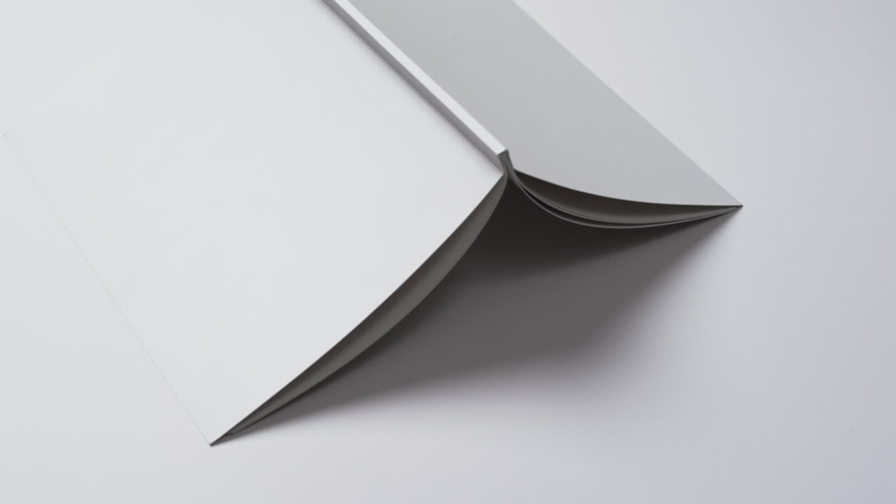 Video of book with white blank cover pages and copy space on white background