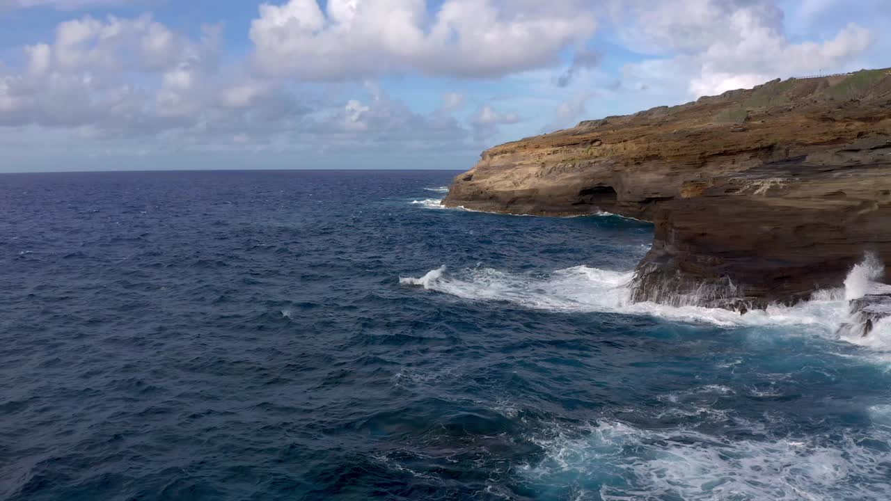 Toma costera con dron en Hawái. Toma de acantilado en cámara lenta con olas.