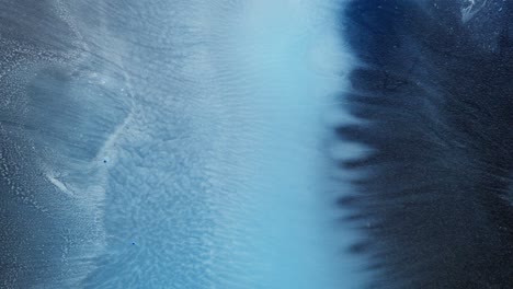 black and blue alcoholic ink blend creates abstract textures in close-up macro view