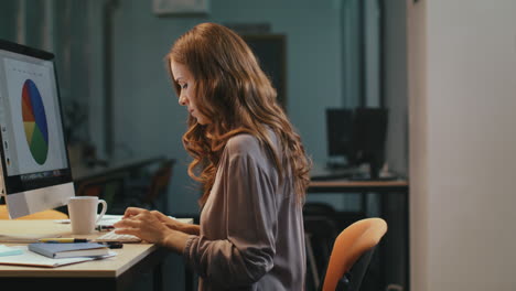 surprised business woman looking at financial report on computer screen at night