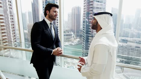 arab businessman national dress meeting western caucasian colleague