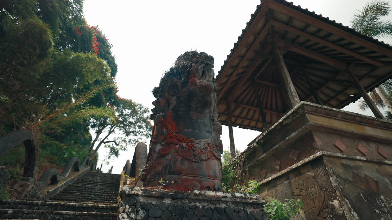 Traditional Balinese Temple Entrance with Stone Guardian Statue and Pavilion