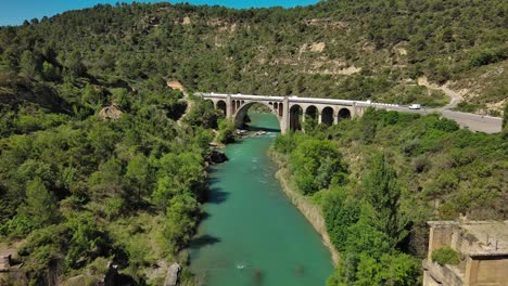 murillo de gallego bridge in huesca over a turquoise river, surrounded by lush greenery, aerial view