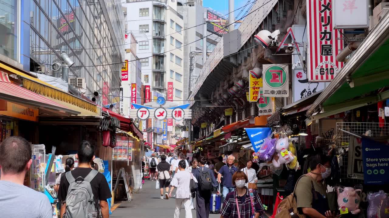 Busy outdoor street market scene in Japan with colorful signs and people walking around