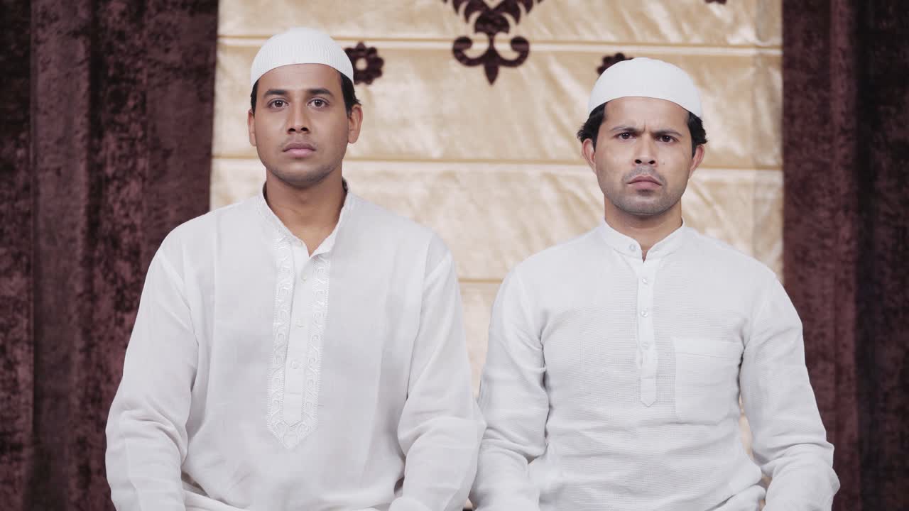 To muslimske mænd kigger på kameraet.