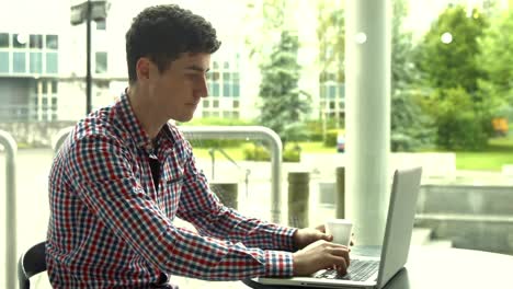 estudiante usando una computadora portátil en una cafetería