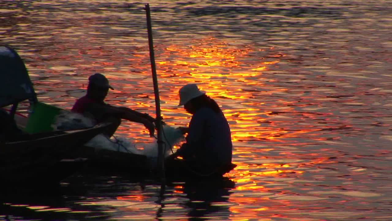 베트남 어부들은 황혼에 카누를 타고 나갑니다.