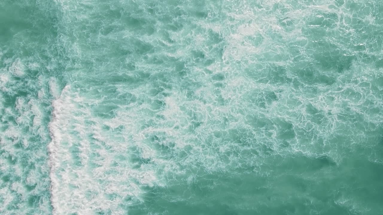 disparo de drones a lo largo del océano con olas rompiendo