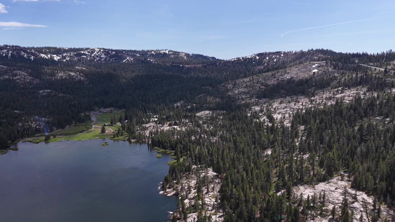 Ampia vista aerea che sorvola lo splendido Silver Lake, rivelando un vasto paesaggio di pineta e montagne innevate sotto un cielo azzurro e limpido a Pioneer, California