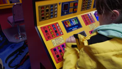 a girl plays bingo on a machine in an amusement arcade