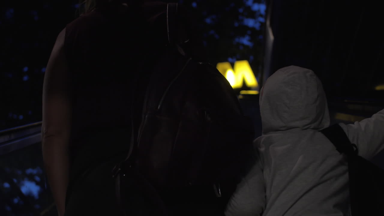 мать и ребенок едут на эскалаторе, чтобы покинуть станцию метро.