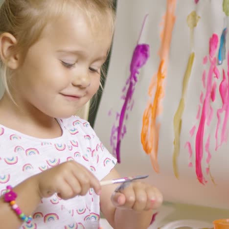 niña aplicando pintura en el dorso de su mano