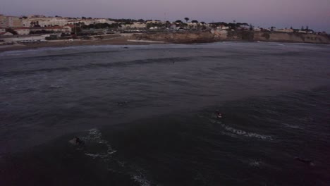 Surfer-pops-up-and-catches-a-wave-in-the-dusk-or-twilight-hours-of-the-evening-surfing-a-shortboard-in-estoril-surf-spot