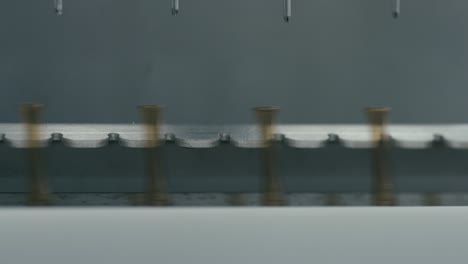 machine with rods that fills bottles with medication in industrial doses, ensuring precise and efficient production.