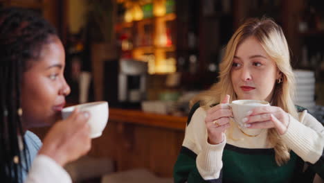 two women drinking coffee in a cafe