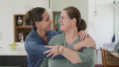 Portrait-of-caucasian-lesbian-couple-looking-at-camera,-embracing