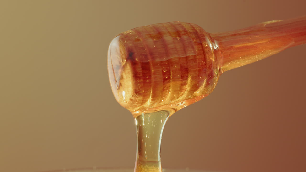 Close-up of Honey Dripping from a Wooden Dipper