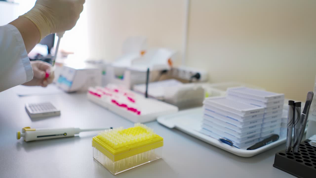 Test tubes on the table in the laboratory. Medical worker in sterile gloves conducts experiments with samples in clinic. Healthcare concept.