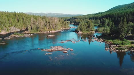 Forward-drone-shot-over-a-river-in-a-large-forest-in-mid-Norway