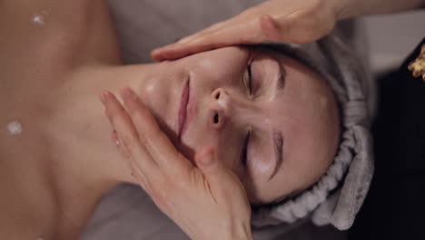 cosmetología terapeuta haciendo mujer relajante spa masaje facial con las manos en el salón, desintoxicación y curación