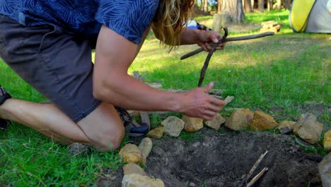 man preparing bonfire in the forest on a sunny day 4k