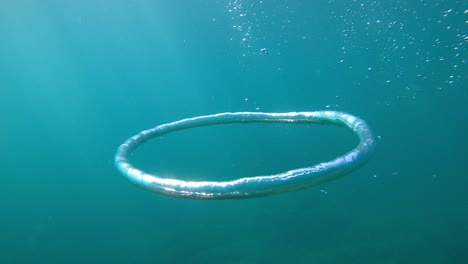 ring bubble and sun underwater in blue ocean. water texture.