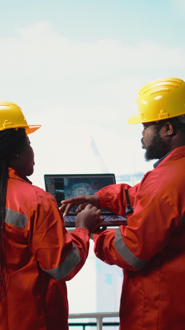 Vertical video Offshore platform crew using artificial intelligence program on laptop
