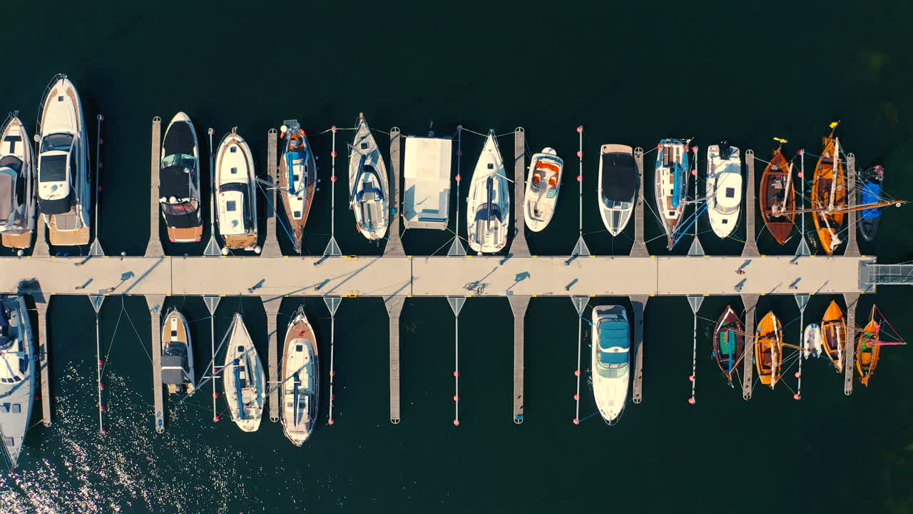 Drone flying around the marina with moored yachts and boats at sunny summer day