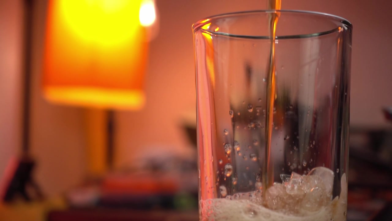 Cola versata sul ghiaccio, sfondo sfocato