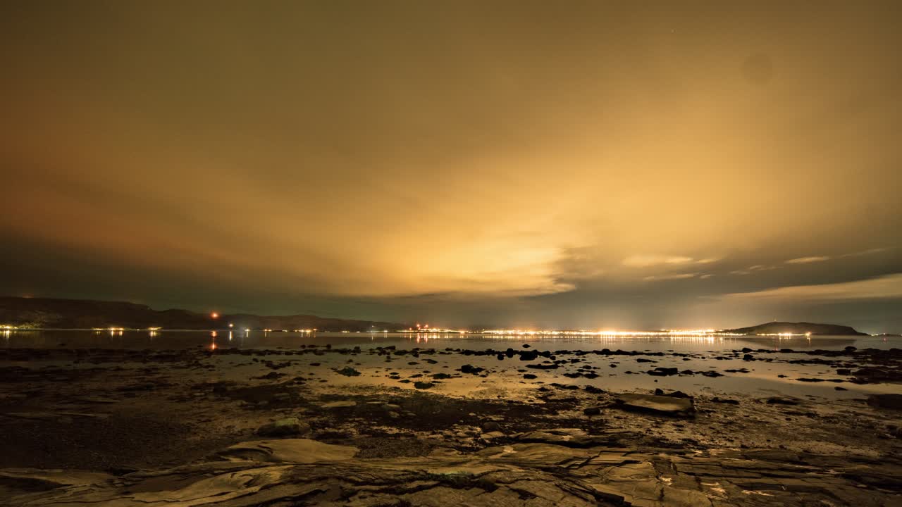 aurora boreal y la luna en una noche nublada sobre el fiordo