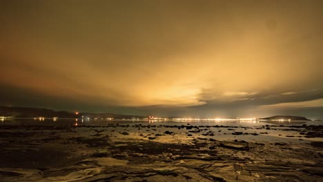 aurora boreal y la luna en una noche nublada sobre el fiordo