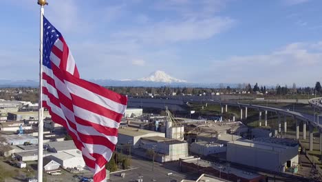 large american flag waving in the wind over city